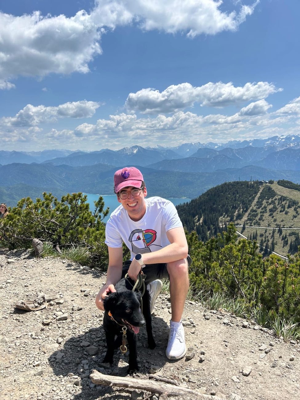 Panos and a black labrador at a mountain summit