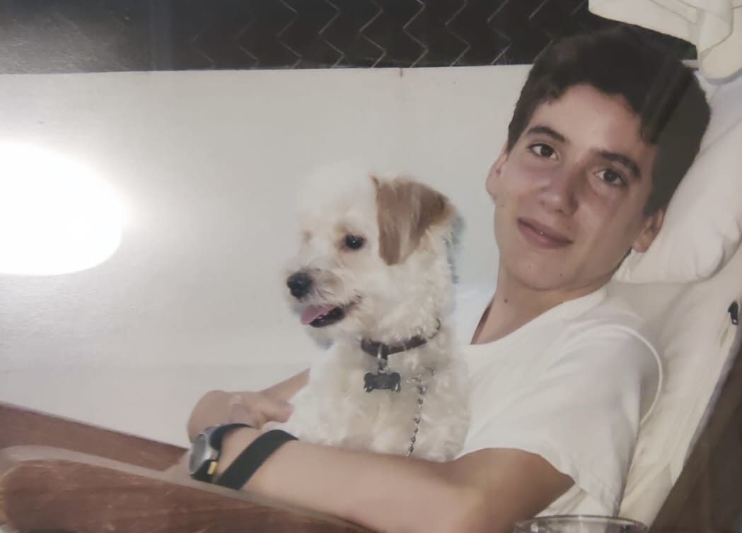 A young Panos holding a small white dog